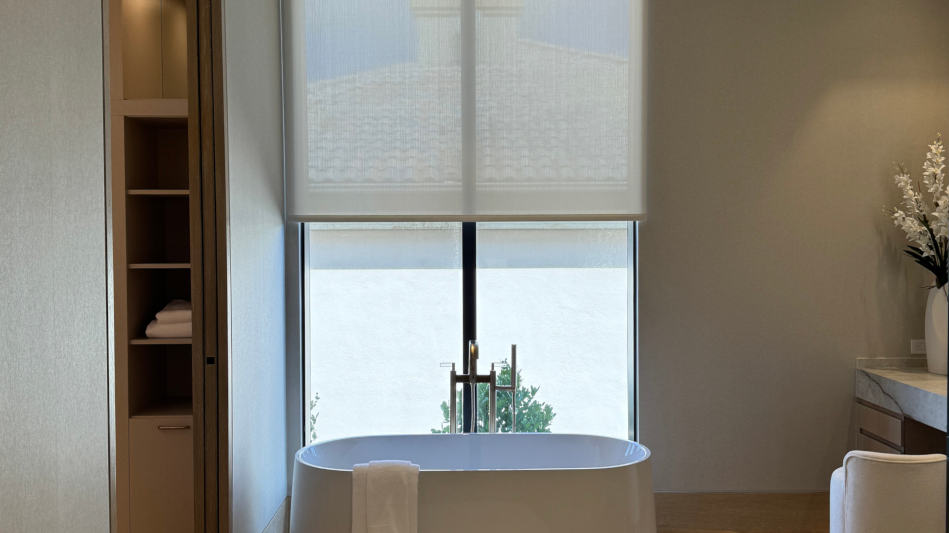 Motorized shade installed above a bathtub